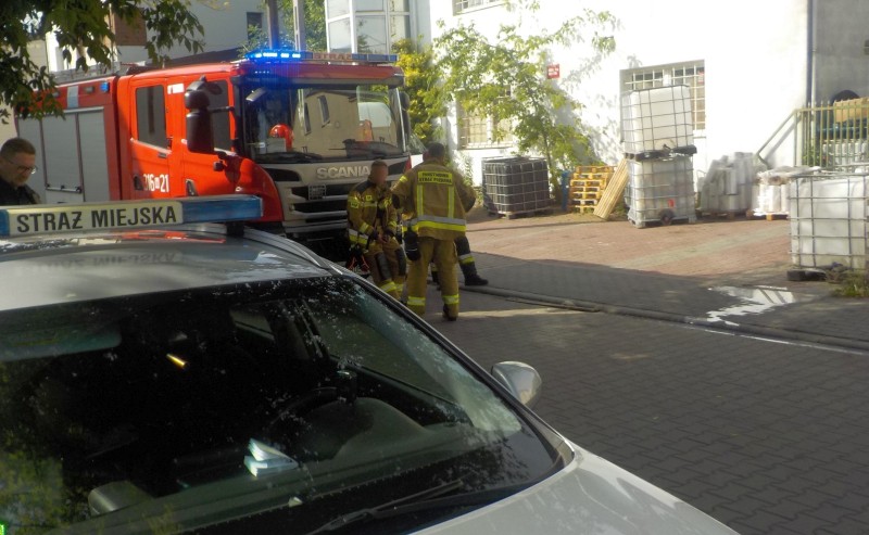 Radiowóz straży miejskiej na miejscu zdarzenia. W tle wóz strażacki oraz strażacy.