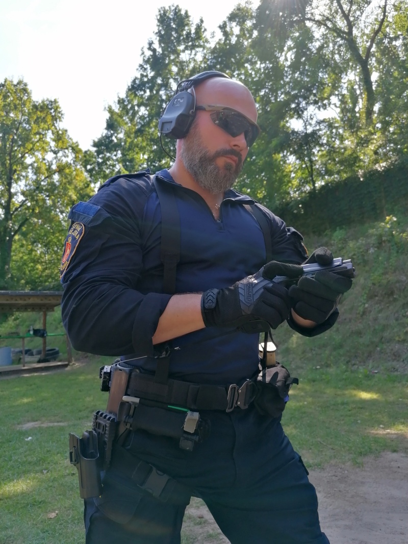 Inspektor Łukasz Capiga z pełnym oprzyrządowaniem strzeleckim na strzelnicy.