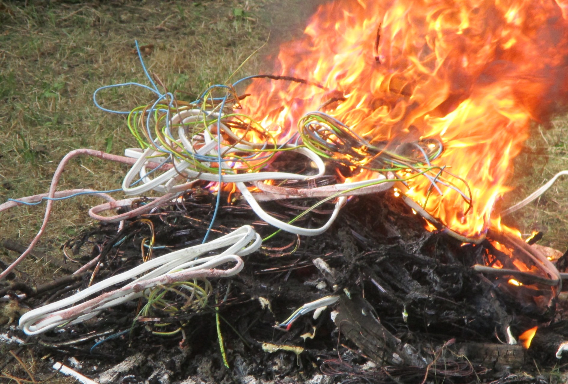 Płonące ognisko, w którym spalane są między innymi kable w plastikowej izolacji.