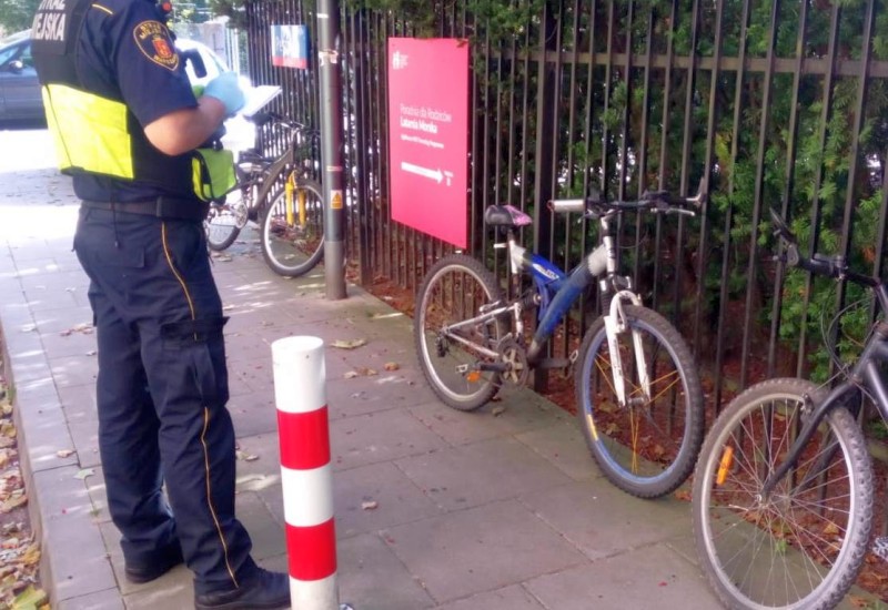 Strażnik miejski stojący obok odzyskanych rowerów.
