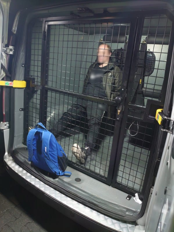 Ujęty mężczyzna zamknięty w przedziale przewozowym radiowozu straży miejskiej