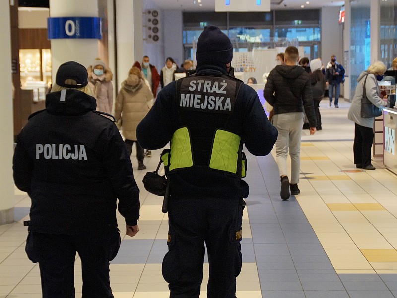 Zdjęcie ilustracyjne: strażnik miejski patrolujący wraz z policjantką centrum handlowe.