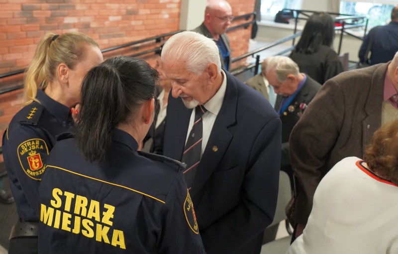 Spotkanie w Domu Wsparcia dla Powstańców Warszawskich: profesor Żukowski rozmawia ze strażniczkami miejskimi.