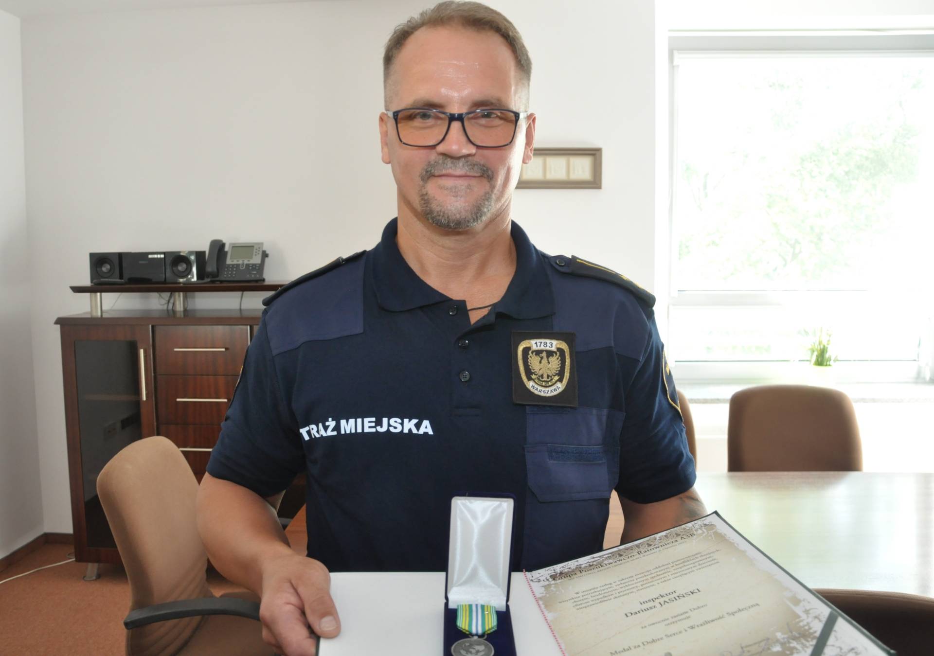 Inspektor Dariusz Jasiński z medalem „Za dobre serce i wrażliwość społeczną” oraz okazjonalnym dyplomem.